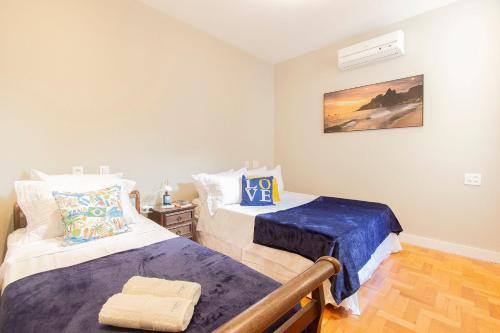 a bedroom with two beds and a night stand at Praia e Conforto em Ipanema! in Rio de Janeiro