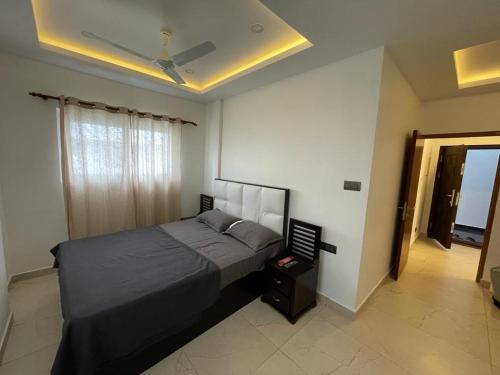 a bedroom with a large bed and a window at BMRAN Luxury serviced apartment in Cochin