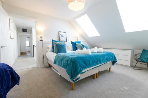 a bedroom with a large bed with blue pillows at Duneside House in Beadnell