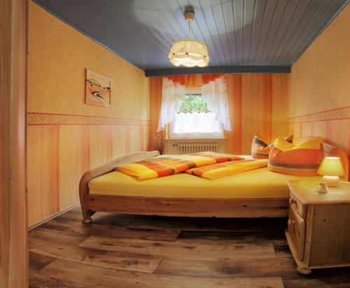a bedroom with a large bed with yellow and orange pillows at Ferienwohnung Rhönblick in Hilders