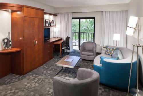 a living room with a couch and a desk at Courtyard by Marriott Miami at Dolphin Mall in Miami
