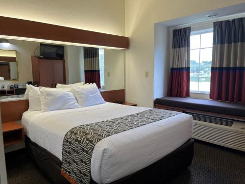 a hotel room with a large bed and a window at Microtel Inn and Suites by Wyndham - Lady Lake/ The Villages in The Villages