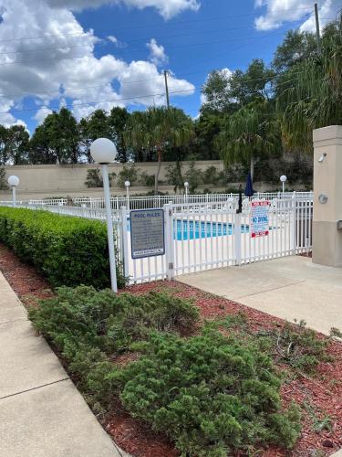 a white fence next to a swimming pool at Microtel Inn and Suites by Wyndham - Lady Lake/ The Villages in The Villages