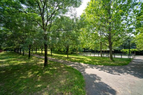 a group of trees in a park with a sidewalk at Oasis Luxury - A.C/Terrace/2Bedrooms in Bergamo