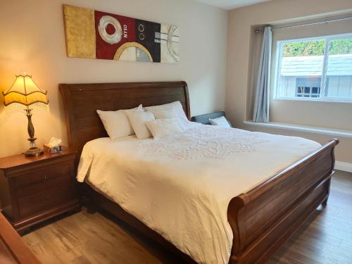 a bedroom with a large bed and a window at Two Bedroom Suite with Private Bathroom and Shared Lounge in West Kelowna