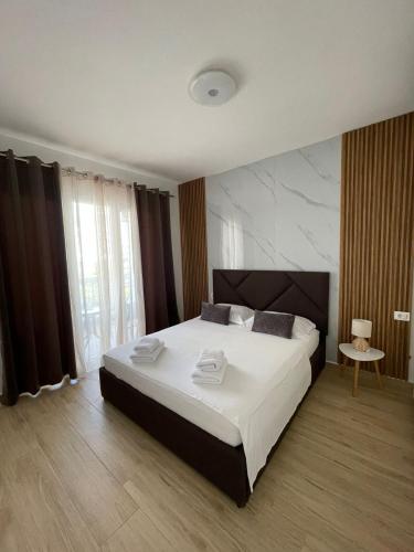 ein Schlafzimmer mit einem großen Bett mit Handtüchern darauf in der Unterkunft Waterfront Apartments in Durrës