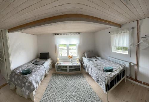 a room with two beds and a window at Loves Bondgård in Sparreholm
