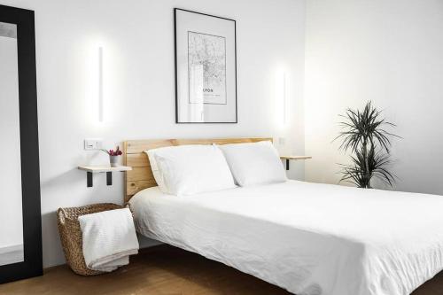 a white bedroom with a large bed with white sheets at Chalet Zenspace in Le Grand-Bornand