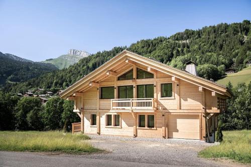 a large wooden house with a garage at Chalet Zenspace in Le Grand-Bornand