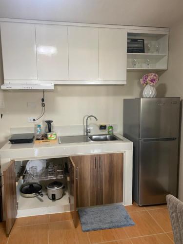 a kitchen with a sink and a refrigerator at Affordable 2 bedroom condo unit in Cagayan de Oro