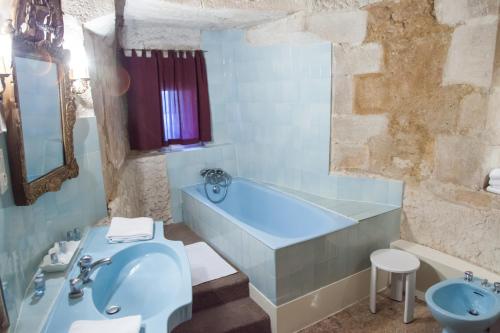 a bathroom with a tub and a toilet and a sink at Château de Bellecroix in Chagny