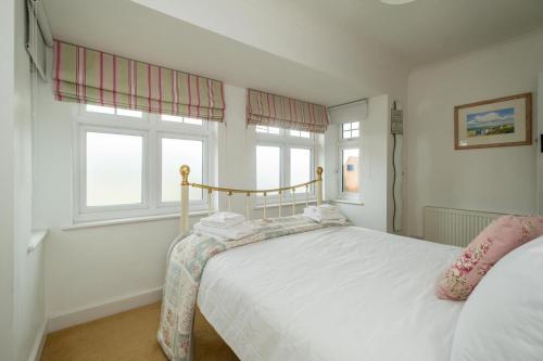 a bedroom with a bed and two windows at 69 Saxmundham Road in Aldeburgh