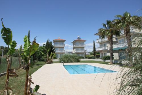 a swimming pool in front of a large house at CARETTA VİLLA in Antalya
