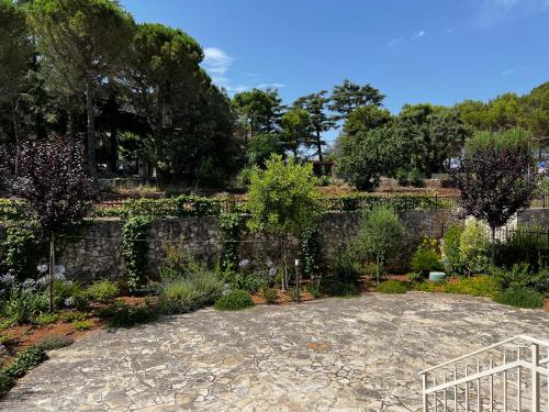 a garden in front of a stone wall at Dimora Di Bari in Selva di Fasano