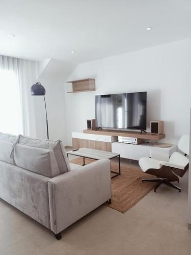 uma sala de estar com um sofá e uma televisão de ecrã plano em Apartamento Santiago de La Ribera em Santiago de la Ribera