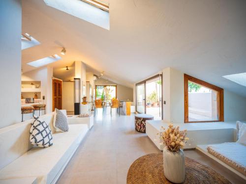a large living room with white furniture and windows at Character filled villa with mature garden in Marbella