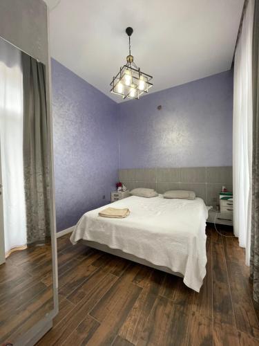 1 dormitorio con cama blanca y pared azul en Baku White Villa en Bakú