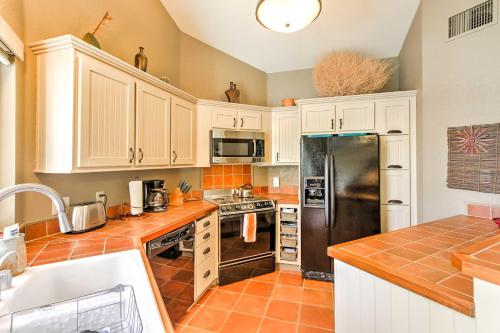 a kitchen with white cabinets and a stainless steel refrigerator at Borrego Springs Condo with Private Hot Tub and Views! in Borrego Springs