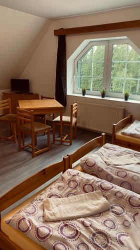 a bedroom with two beds and a table and a window at Horské Apartmány Smrčina in Janske Lazne