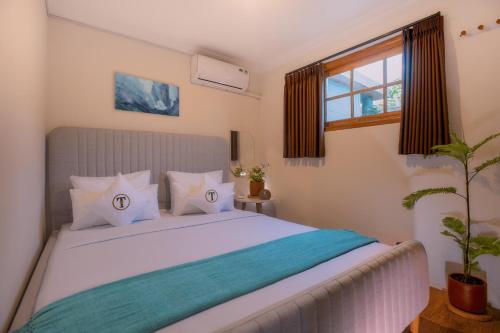 a bedroom with a large white bed with a window at Tzy-No Family Cottage in Balong