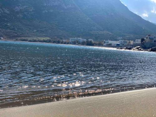 a beach with a body of water and a mountain at Apollon Sunrise in Apollon
