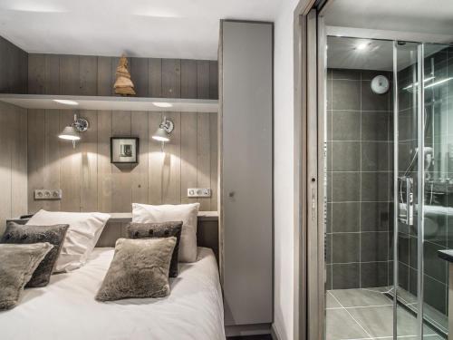 a bedroom with a bed and a glass shower at Salers : Elegant 3 pièces rénové avec grand salon et salle à manger, centre Moriond, 4/6 personnes - FR-1-563-8 in Courchevel