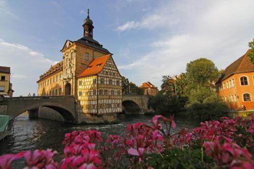 a building next to a river with a bridge at Flair-Hotel Zum Benediktiner in Schwarzach am Main