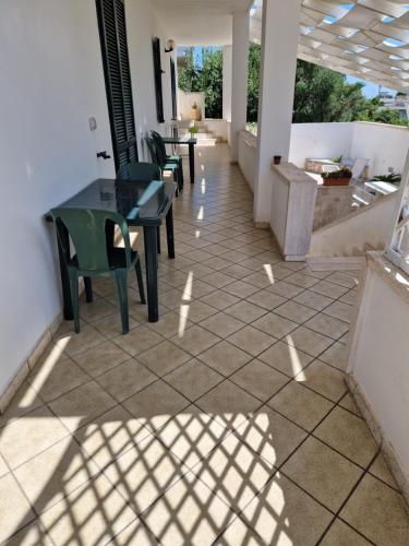 un patio con sedie e tavolo su un pavimento piastrellato di Case vacanza Mancaversa a Taviano