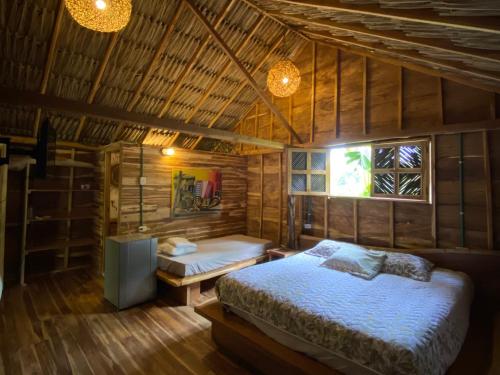 1 dormitorio con 1 cama en una habitación de madera en Cabañas roble verde, en Rincón