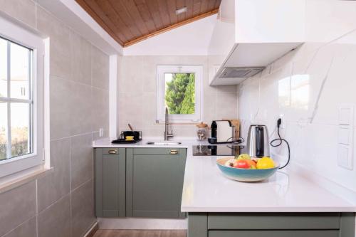 a kitchen with a bowl of fruit on a counter at Host Wise - Rustic Adorable House in Old Village in Aldeia Nova
