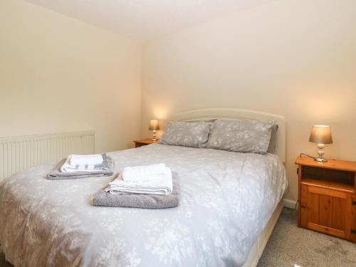 um quarto com uma cama com toalhas em Petlyns Patch em Holyhead