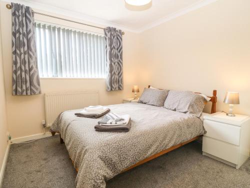 a bedroom with a bed and a window at Petlyns Patch in Holyhead