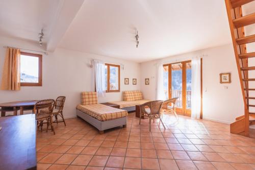 sala de estar con sofá, mesa y sillas en Chalet Clos Gauthier, en La Salle-les-Alpes