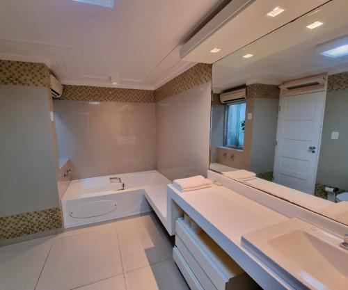 a bathroom with two sinks and a bath tub at Palace Residence in Garanhuns