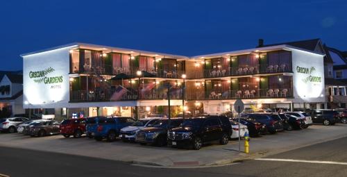 a large building with cars parked in a parking lot at Grecian Garden Motel in North Wildwood