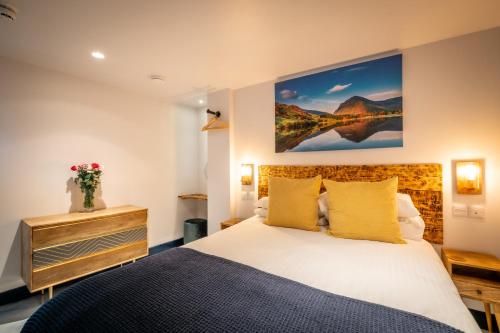 1 dormitorio con 1 cama y una pintura en la pared en Brand New Apartment Central Location Hot Tub en Bowness-on-Windermere