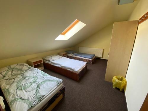 a bedroom with two beds and a skylight at Chata Jahodná in Košice