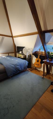 a bedroom with a bed and a guitar in a room at Directors room Swimmingpool Ecolodge Tilburg in Tilburg
