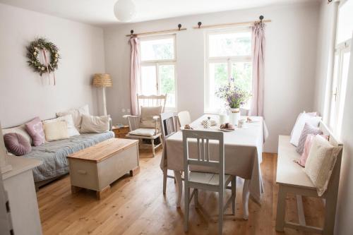 een woonkamer met een tafel en een bank bij Domeček na Květinovém statku in Zdice