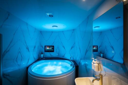 een blauwe badkamer met een toilet en een bad bij Brand New Apartment Central Location Hot Tub in Bowness-on-Windermere