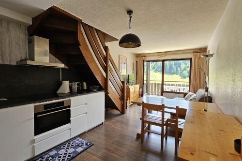 a kitchen with a table and a dining room at 3-star apartment with view in La Clusaz