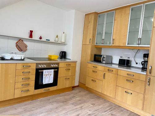 a kitchen with wooden cabinets and a stove top oven at Feriendomizil Mühlenblick in Xanten