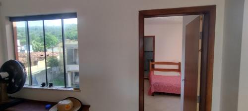 a room with a window and a bedroom with a bed at Cobertura Pé na Areia 15 m Mar in Olivença