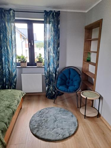 um quarto com uma cadeira azul e uma janela em JELONEK em Jelenia Góra