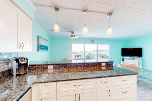 大洋城的住宿－Assateague House 306，厨房设有蓝色的墙壁和台面