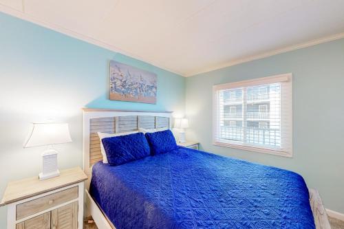 大洋城的住宿－Assateague House 306，一间卧室设有蓝色的床和窗户。