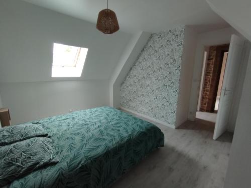 ein Schlafzimmer mit einem Bett mit einer grünen Bettdecke in der Unterkunft La Grange proche mer avec spa en option in Saint-Germain-le-Gaillard