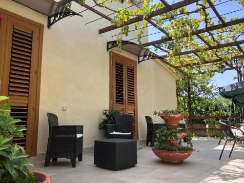 a patio with chairs and a pergola with plants at Casa Himera Fontane Bianche in Fontane Bianche