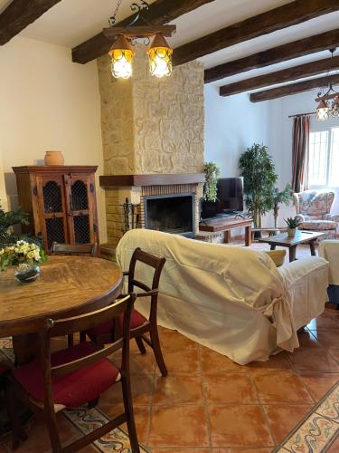 a living room with a table and a fireplace at Close to Sierra Nevada Casa Con Chimenea y Parking Las Golondrinas in Güéjar-Sierra