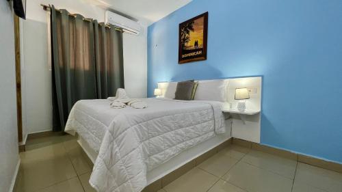 1 dormitorio con 1 cama con pared azul en Chill Boutique Hotel, en Las Terrenas